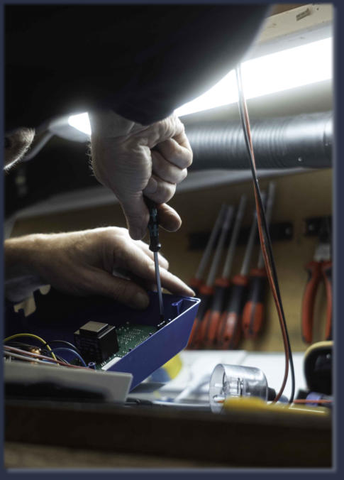 Neutronics engineer repairing industrial circuit board at electronics workbench
