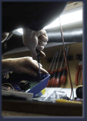 Neutronics engineer repairing industrial circuit board at electronics workbench