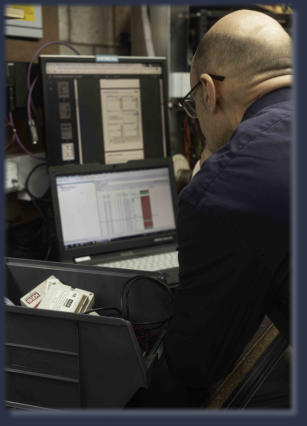 Neutronics engineer analysing diagnostic data and schematics on dual monitors during electronics training session